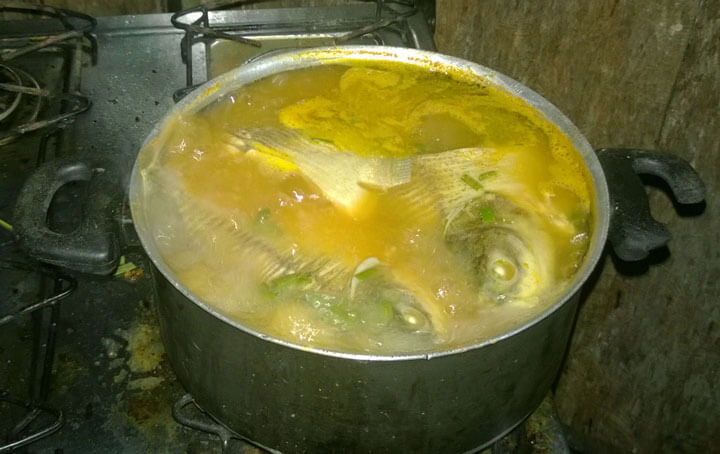 Suppe aus selbstgefangenen Fischen auf dem Gasherd in der einfachen Küche.